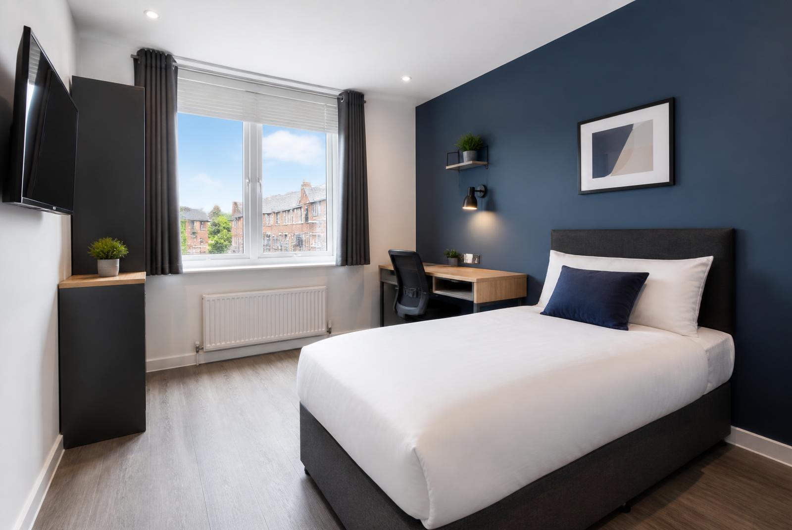 Modernes Monteurzimmer mit Bett, Schreibtisch und TV in St. Veit an der Glan